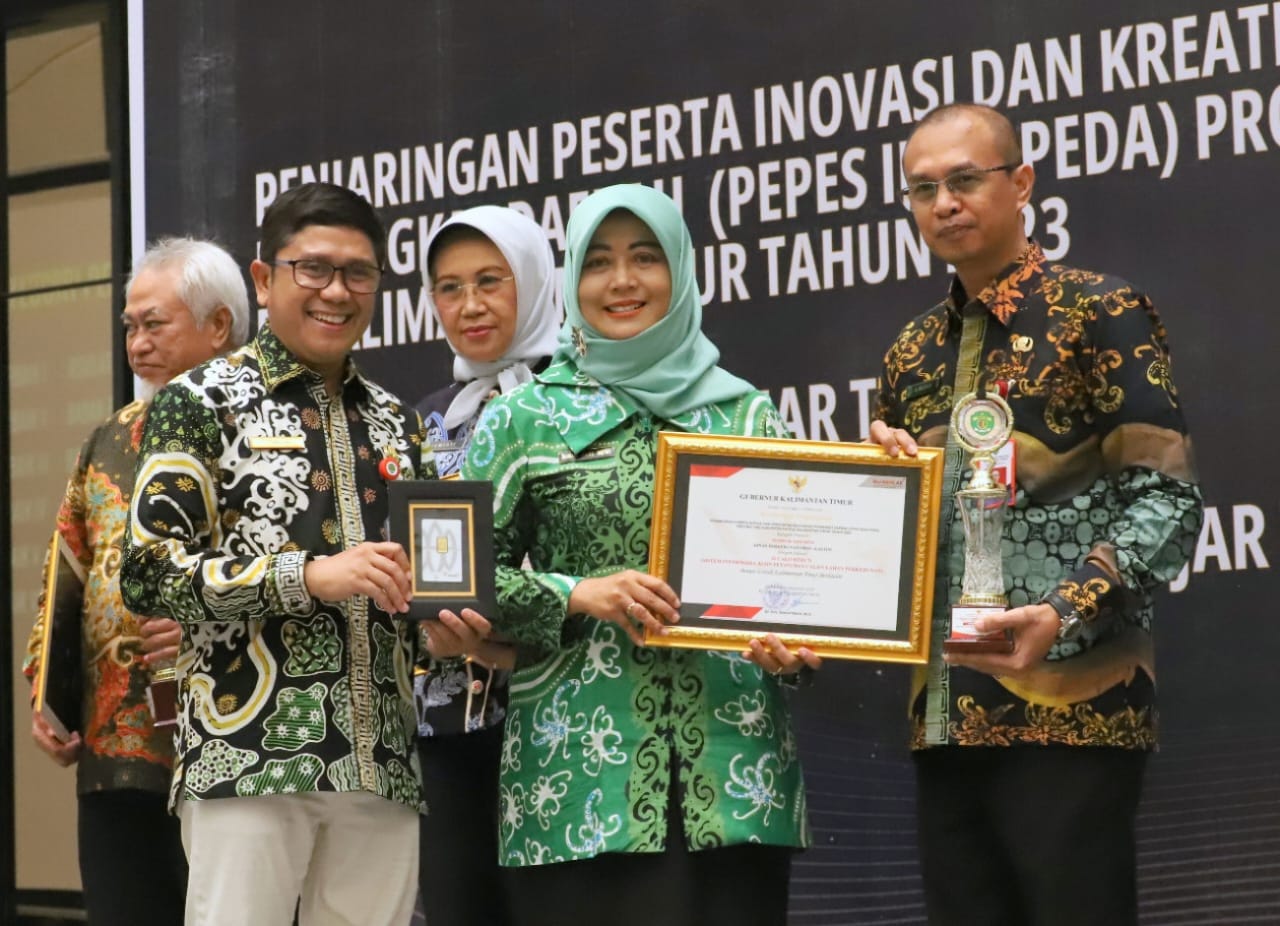 Kepala Dinas Perkebunan Kaltim, Ahmad Muzakkir menerima penghargaan yang diserahkan Staf Ahli Gubernur Bidang Polhukam, Ririn Sari Dewi (dok. Ist)